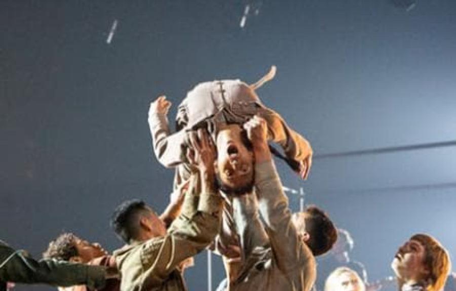Dancers performing as one is lifted in air
