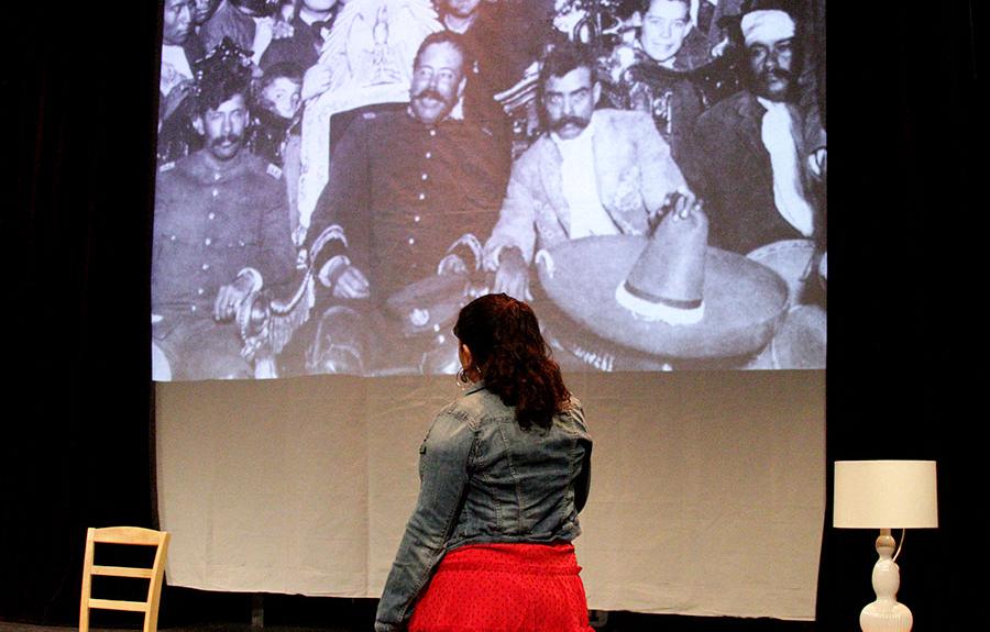 A photo of A Chicano's Guide to Navigation with an actress and a projected photo on stage