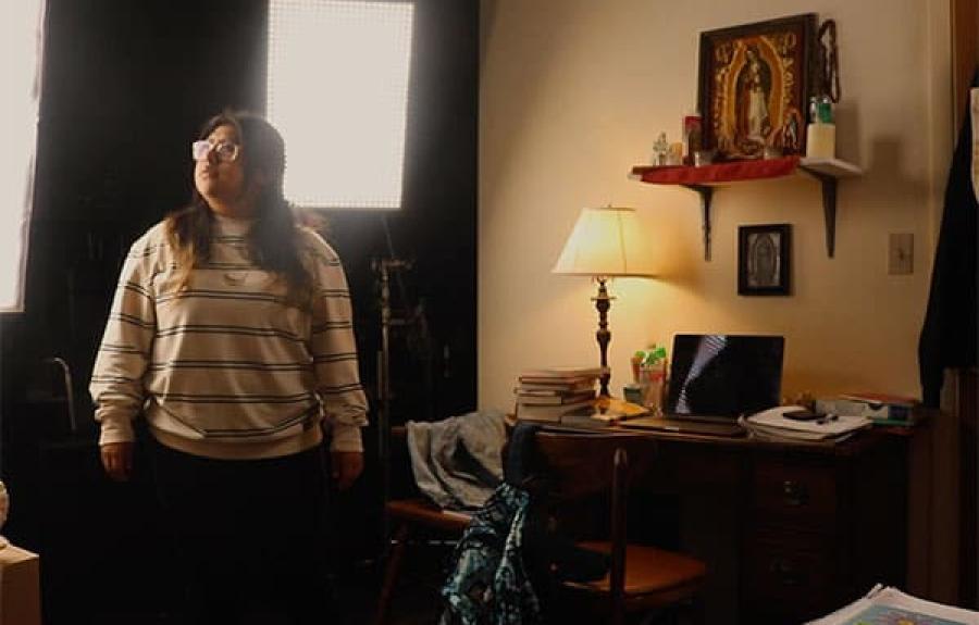 Young woman in glasses and a striped shirt standing in an office