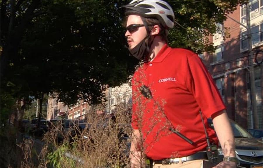 Official in red shirt, sunglasses, and bike helmet on patrol