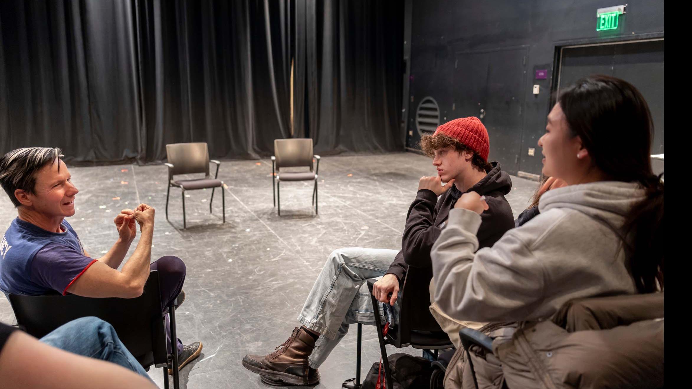 John Cameron Mitchell sits in the first row of the audience in the Black Box Theatre and speaks to students seated in the audience. Photo credit: Simon Wheeler