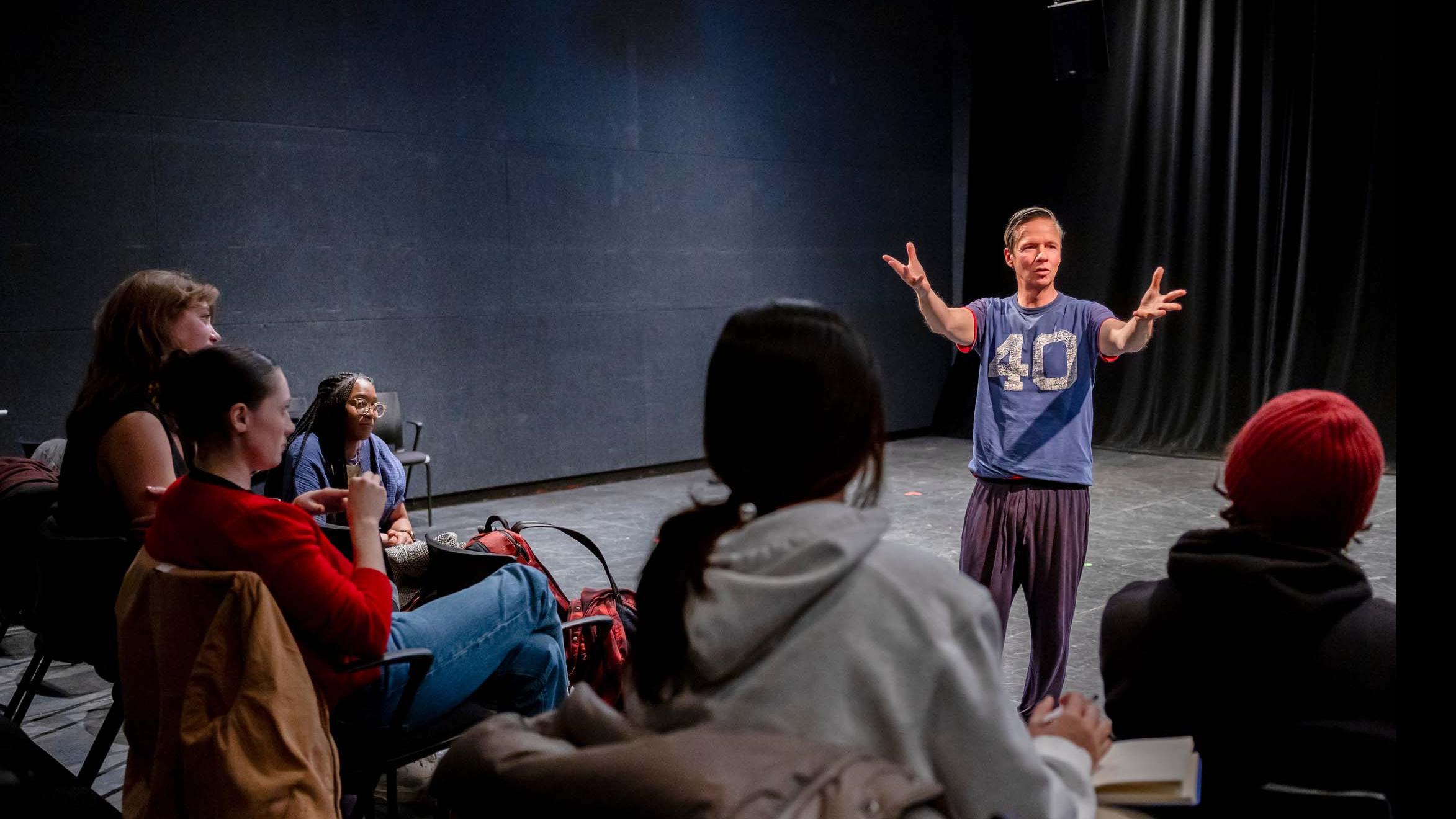 John Cameron Mitchell stands in the Black Box Theatre and speaks to students seated in the audience. Photo credit: Simon Wheeler