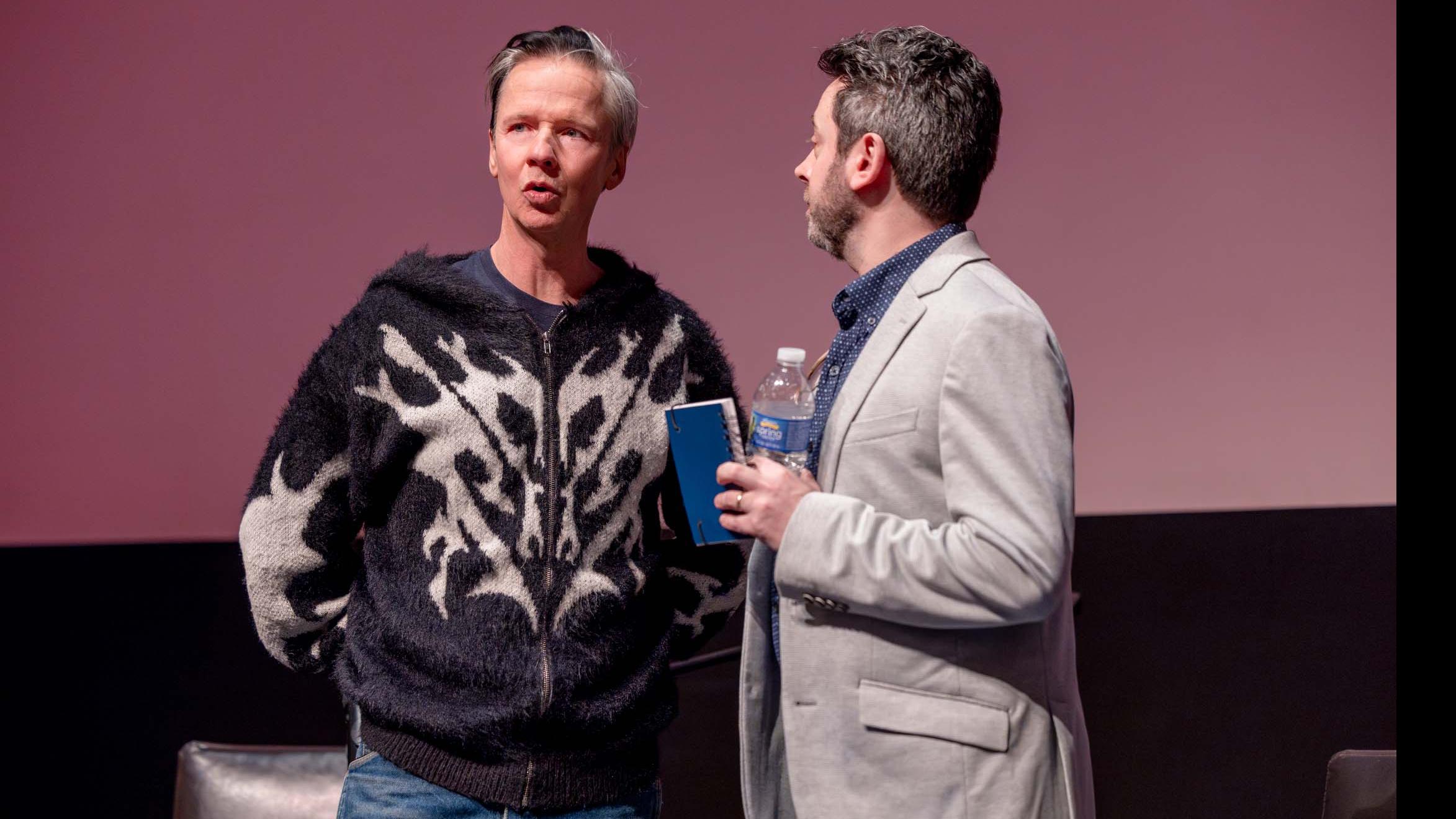John Cameron Mitchell PMA faculty member Nick Salvato stand and talk on stage in the Kiplinger Theatre. Photo credit: Simon Wheeler