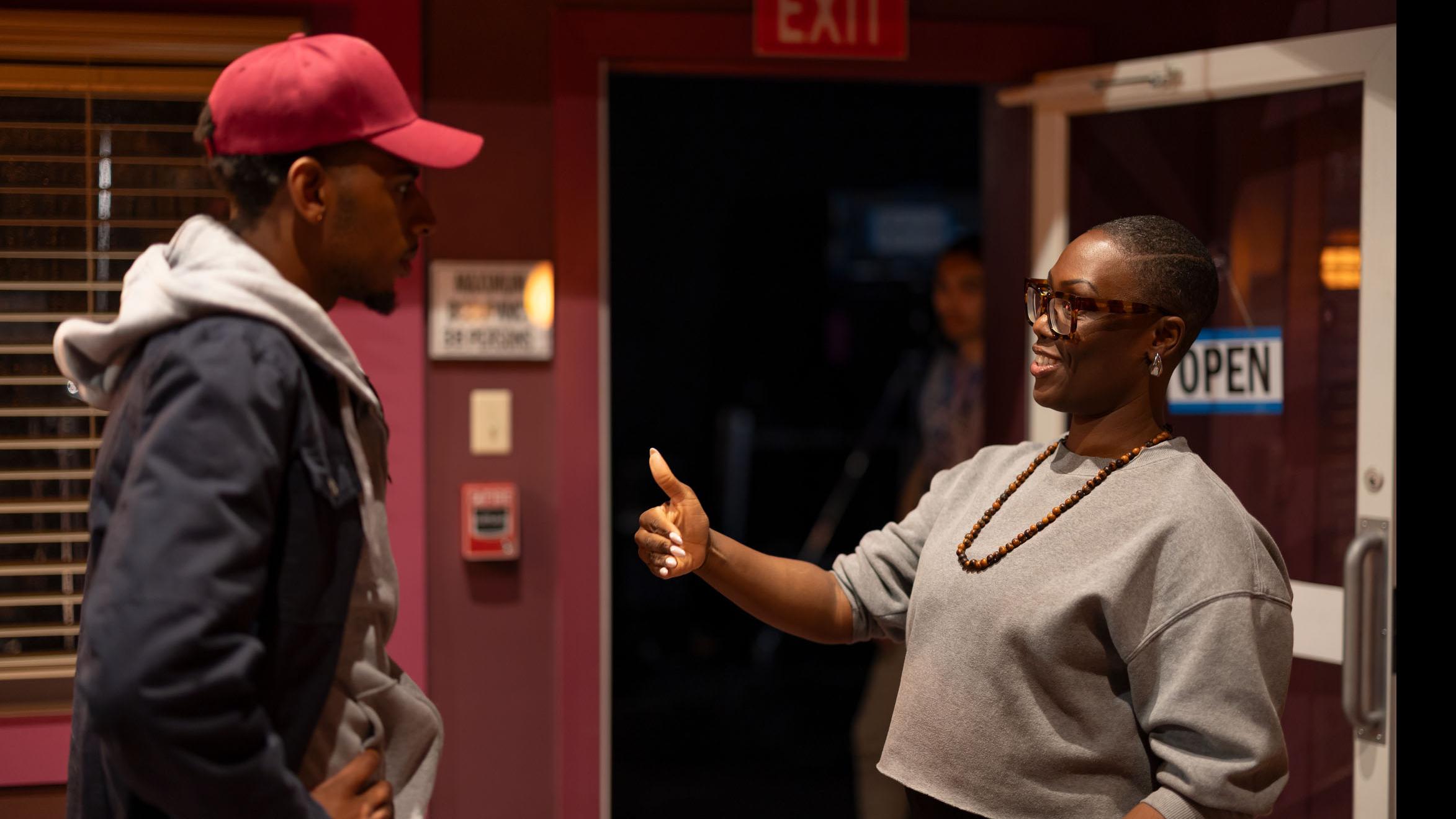 PMA Visiting Lecturer Carolyn Michelle Smith speaks with a student actor by a doorway on the set of the PMA Studios short film Milkshake Kiss. Photo credit: Simon Wheeler