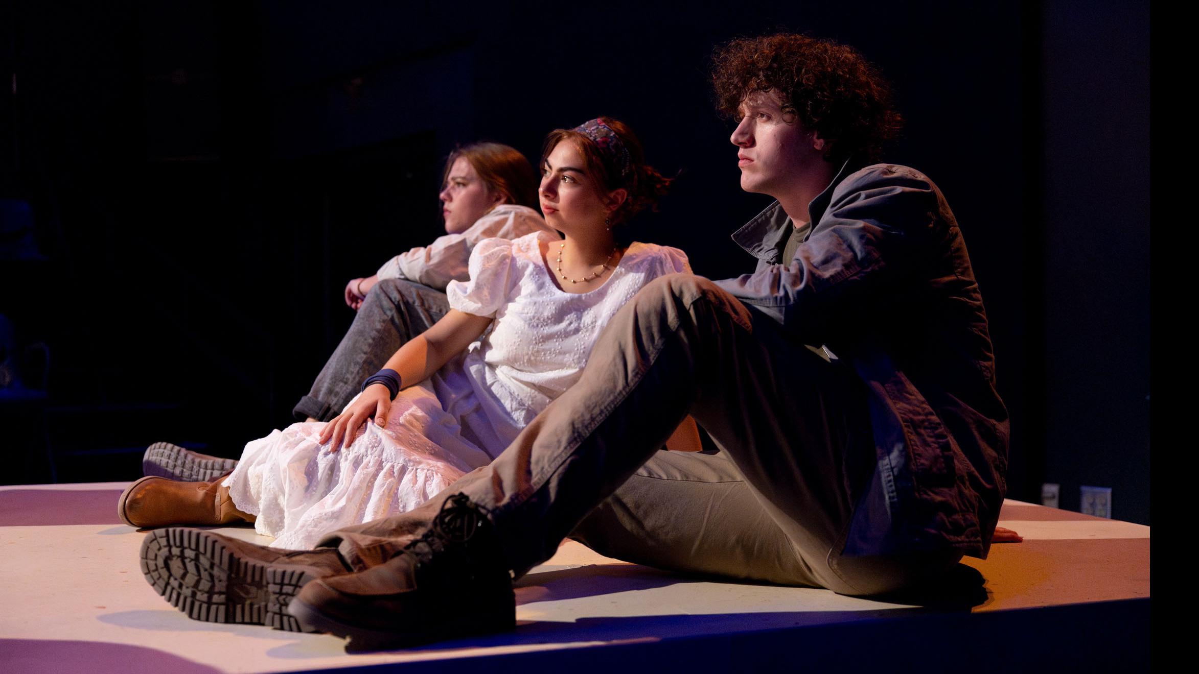 Three cast members sit and look ahead during a performance of I Want a Country in the Flex Theatre, Schwartz Center for the Performing Arts.