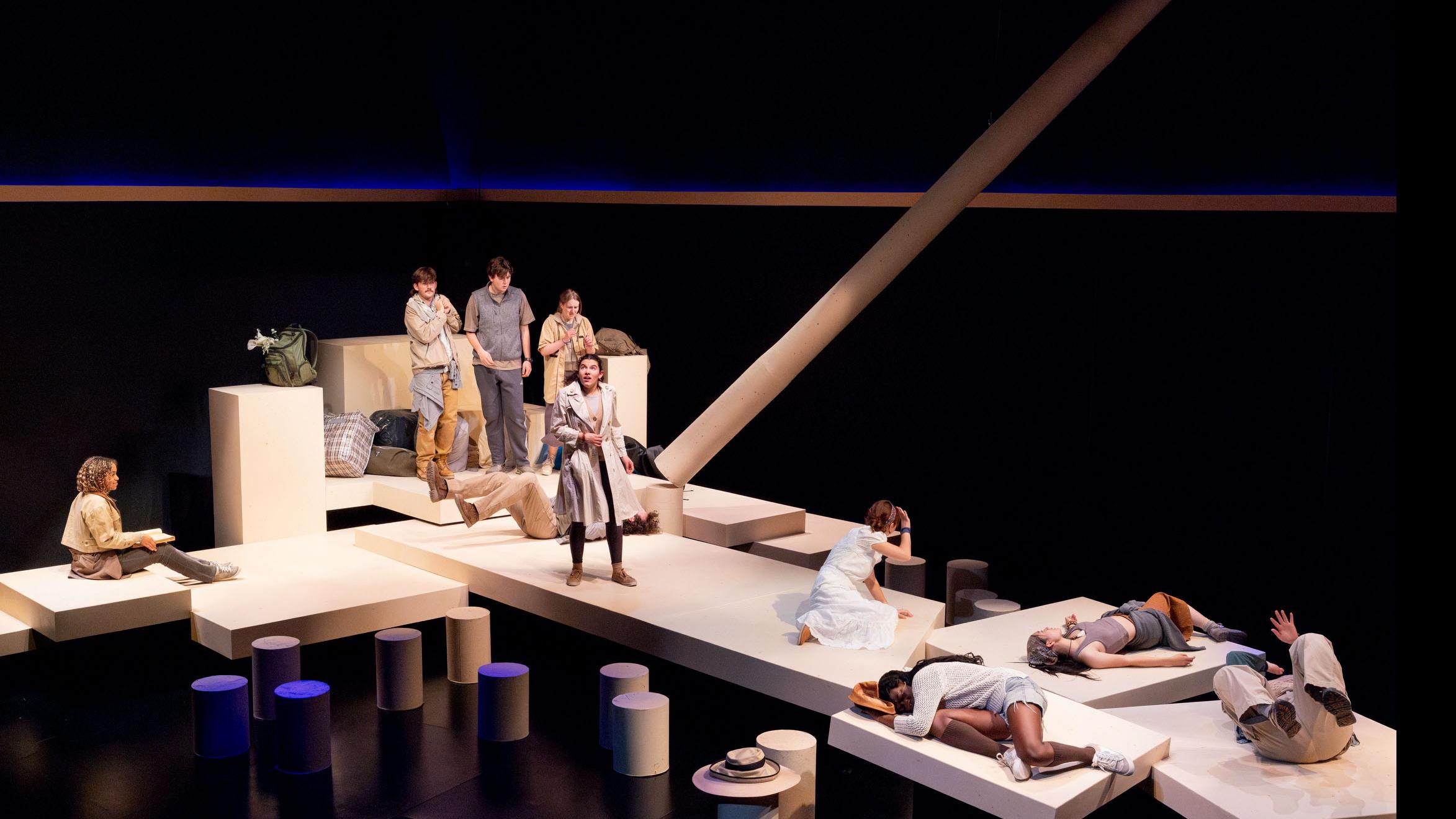 An ensemble of performers standing and lying down spread across the stage during a performance of I Want a Country in the Flex Theatre, Schwartz Center for the Performing Arts.