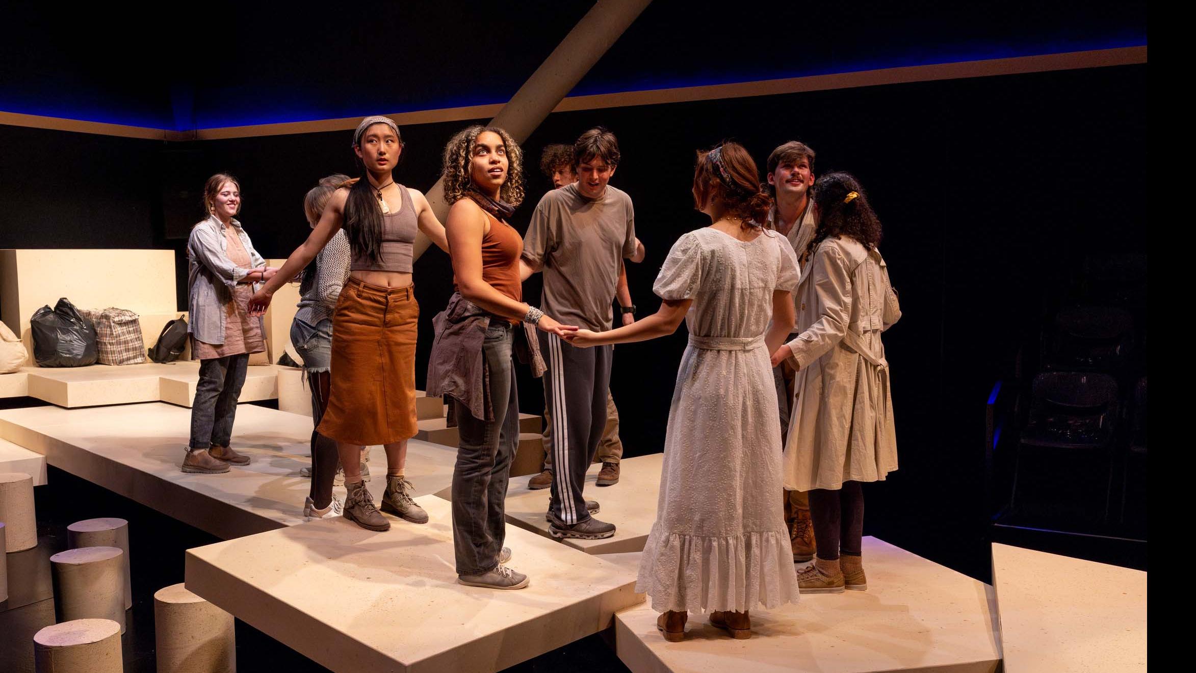An ensemble of performers hold hands during a performance of I Want a Country in the Flex Theatre, Schwartz Center for the Performing Arts.