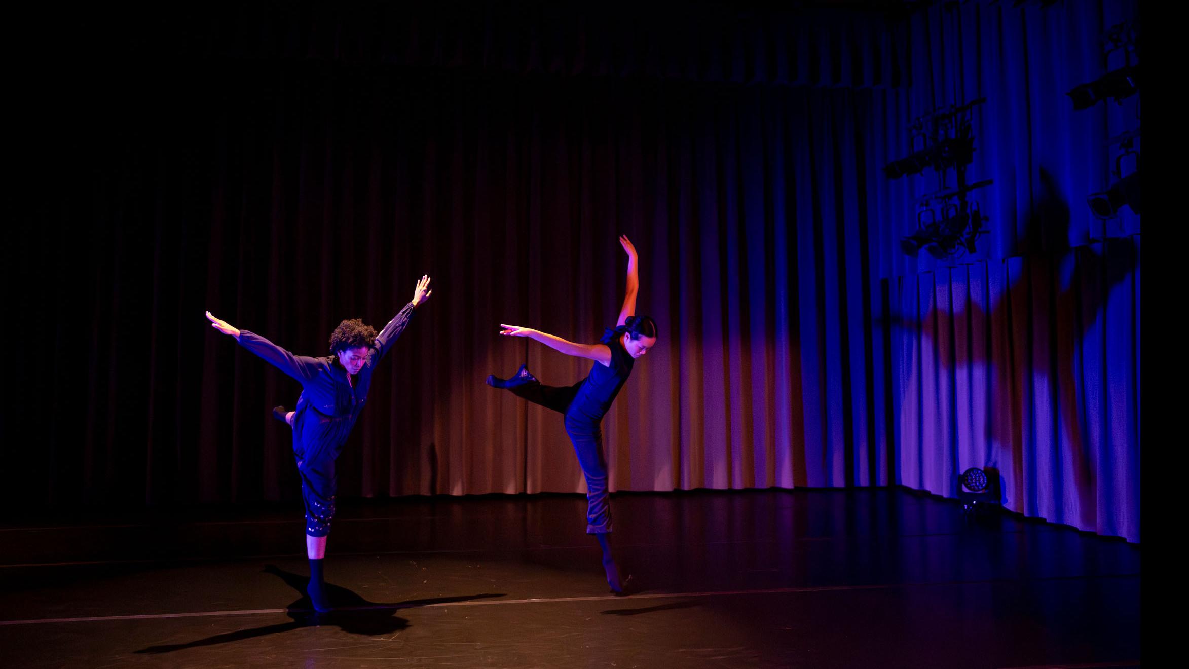 On left, Taylor Janeen Pryor, on right Avery Wang in movement poses during Share In / Share Out in the Class of ’56 Dance Studio Theatre, Schwartz Center.