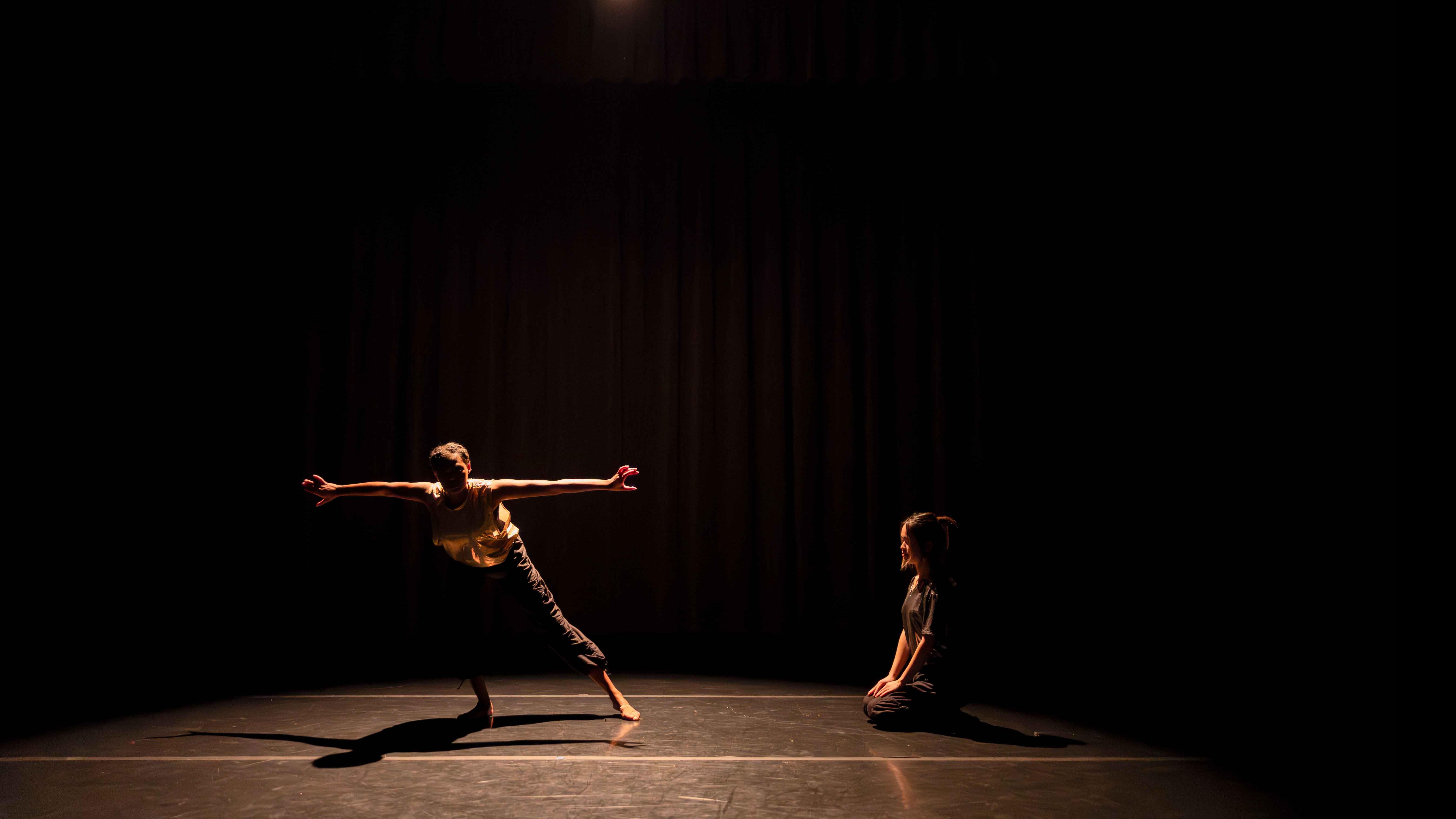 On left, Amirah Ricks, on right Agnes Sun in movement poses during Share In / Share Out in the Class of ’56 Dance Studio Theatre, Schwartz Center.