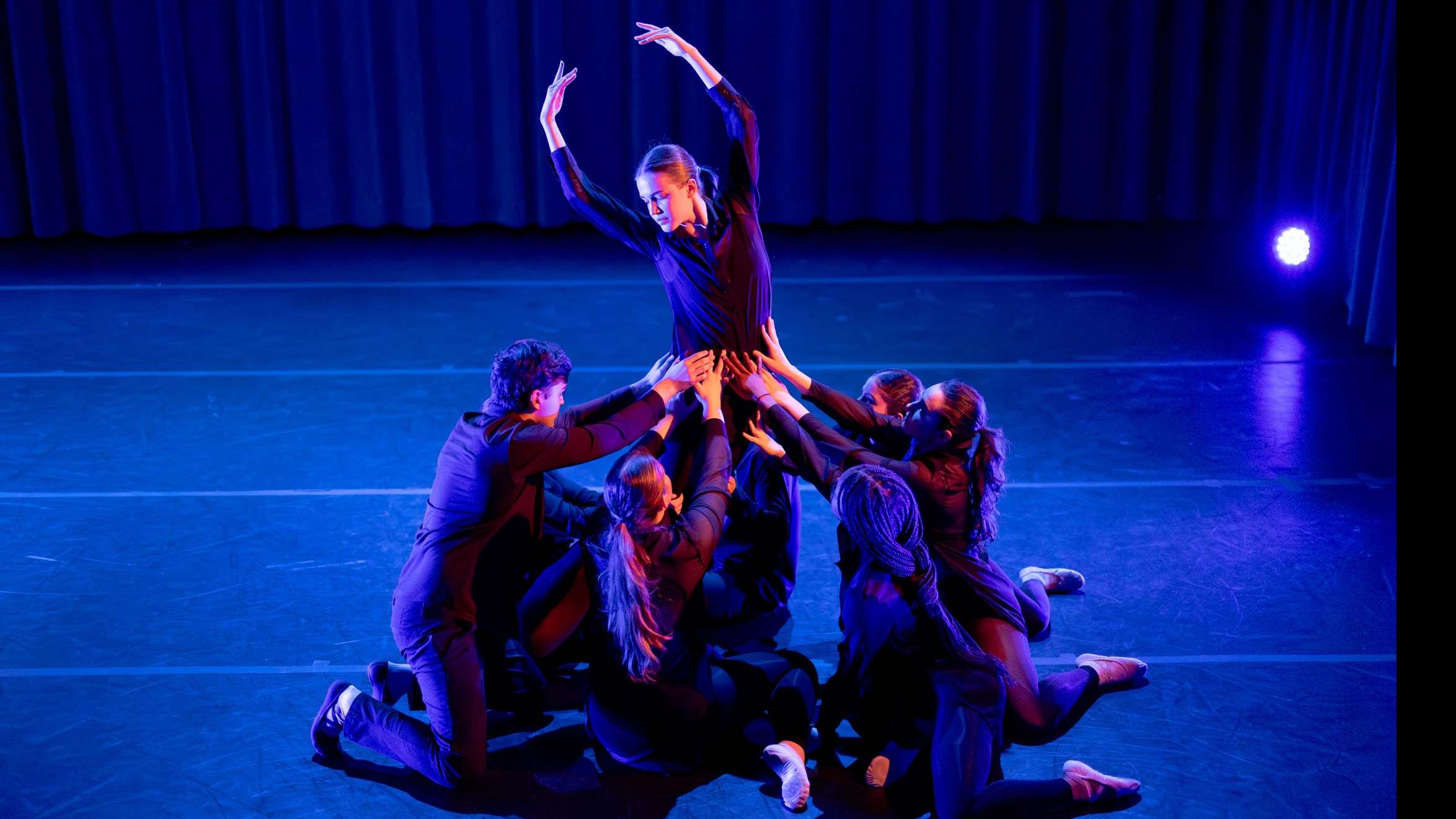 Ensemble in movement poses during Share In / Share Out in the Class of ’56 Dance Studio Theatre, Schwartz Center.