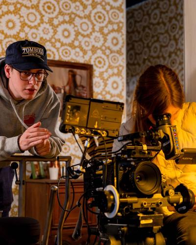 Director Peter Levine, and Director of Photography Indeana Underhill, look through a film camera on the set of Remembering Colin Stall