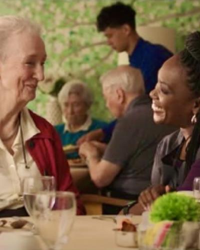 Two actors smiling at each other captured in the film "Familiar Touch"