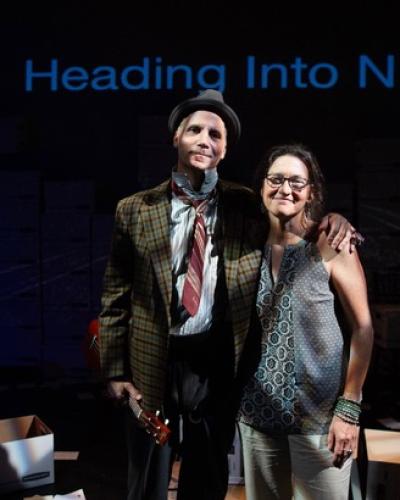 Beth F. Milles and Daniel Passer in front of a sign that says Heading into Night. Photo credit: Cooper Bates