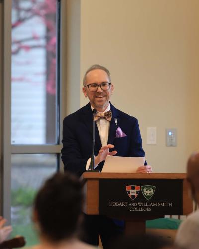 Joshua Bastian Cole-Kurz speaking to an audience from a podium that says Hobart and William Smith Colleges