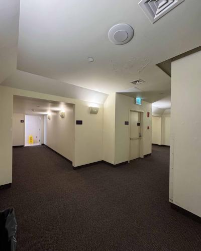Multi-person women’s and men’s bathrooms in the basement of the Schwartz Center for the Performing Arts, with an elevator on the right.