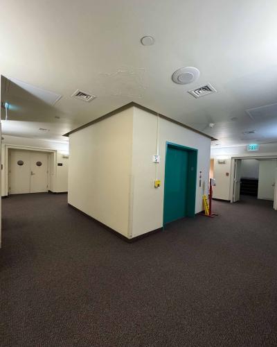 Elevator in the basement of the Schwartz Center for the Performing Arts, with a doorway leading to stairs down to the Class of ’56 Dance Studio Theatre on the left, and stairs leading up to the main floor on the right.