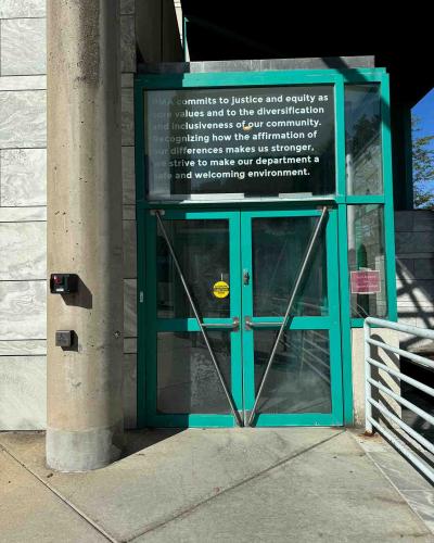 Front double doors of the Schwartz Center for the Performing Arts, with an ADA push button to the left of the doors.