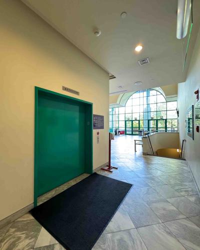 Elevator on the main floor of the Schwartz Center for the Performing Arts lobby, with stairs leading down to the basement on the right.