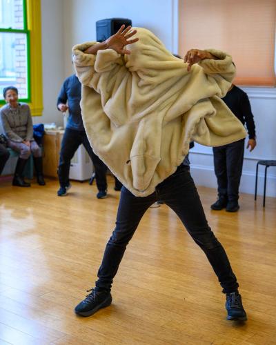 Juan Manuel Aldape Muñoz in a movement pose covered by a blanket at Dance Mission Theatre
