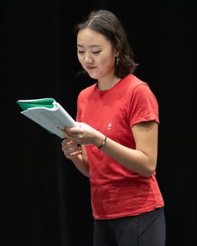Duoer Jia ’21 reads from a script during rehearsal for The Wolves